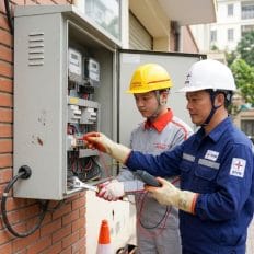 Ảnh chụp kỹ thuật viên Viettel Construction đang làm việc với cán bộ điện lực tại tủ công tơ.