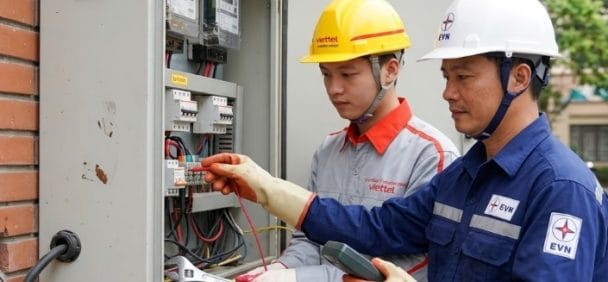 Ảnh chụp kỹ thuật viên Viettel Construction đang làm việc với cán bộ điện lực tại tủ công tơ.